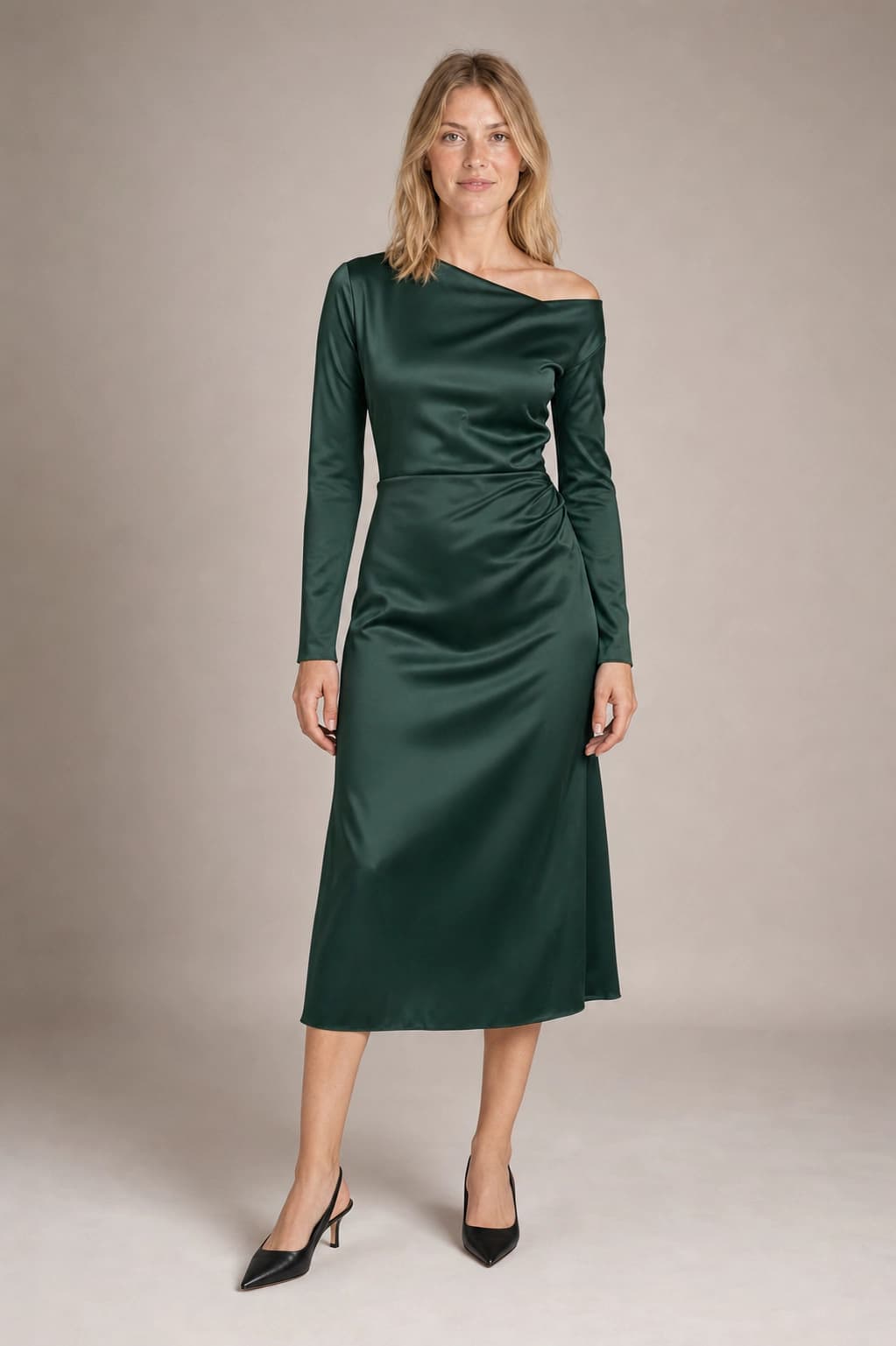 Catalog fashion photograph of the same adult blonde model in a forest-green satin dress