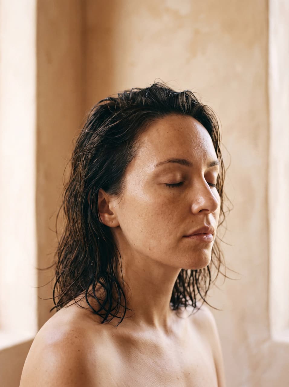Moodboard tile: bare-skinned portrait in warm plaster light, eyes closed